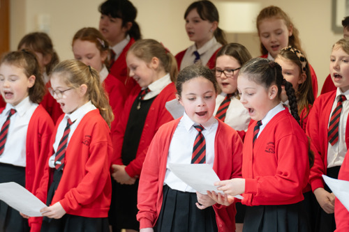 Children in a school choir singing.