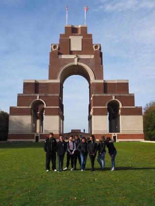 Youth group posing in front of monumental arch