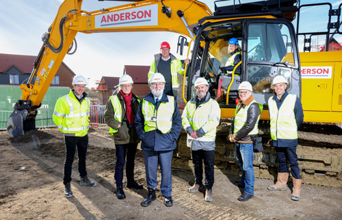 Tracy and Anderson Group in front of a digger