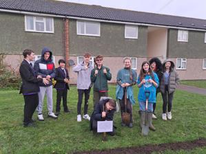 Students from Trinity School, Sevenoaks with smiling faces and their thumbs up as they plant hedges.